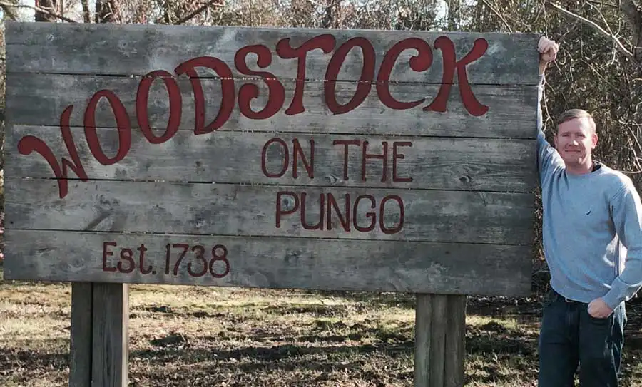 David Hudson in front of Woodstock on the Pungo sign